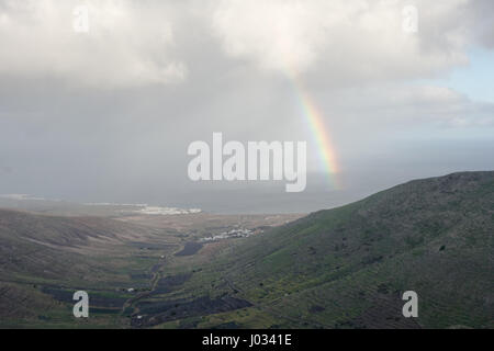 Ein Regenbogen mit Blick auf La Caleta im Norden von Lanzarote, Kanarische Inseln. Stockfoto