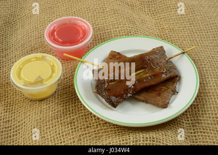 Chinesisches Essen Vorspeise von Rindfleisch-Spieße in pikanter Sauce mit kleinen Behältern von süß und sauer Sauce und Senfsauce Stockfoto
