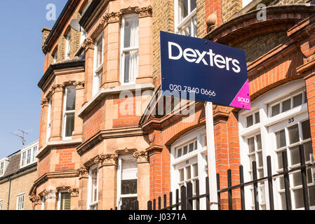 London, England, UK - April 2017: Immobilienmakler Schild draußen eine Reihe von viktorianischen Reihenhäusern in London, England, UK. Dexters, führt in London Stockfoto