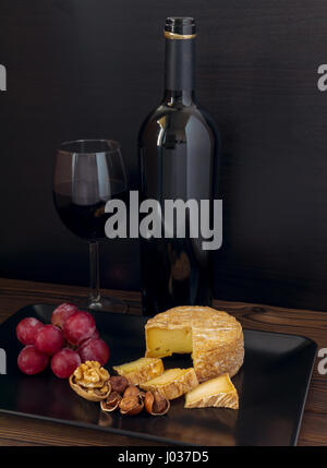 Waschen-Rinde Käse, Haselnüsse, Walnuss, Rote Traube und Wein im Glas und Flasche Stockfoto