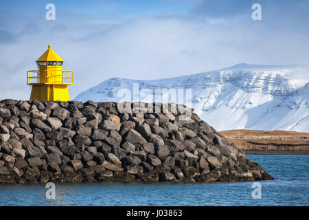 Gelben Leuchtturm auf steinernen Wellenbrecher, Eingang zum Hafen von Reykjavik Stockfoto