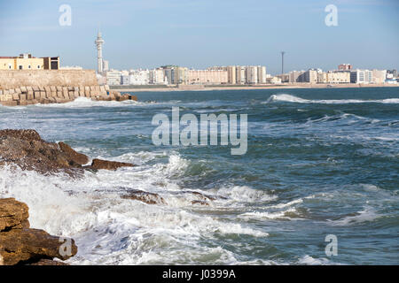 Wellen schlagen die Felsen an der Strandpromenade von La Caleta Strand in Cadiz, Spanien Stockfoto