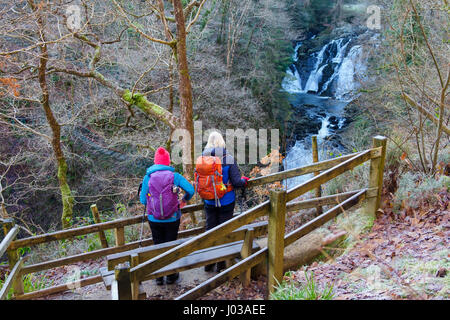 Zwei Wanderer betrachten Swallow Falls (Rhaeadr Ewynnol) auf Afon Llugwy Fluss aus Sicht auf Nordseite. Betws-y-Coed, Conwy, Wales, UK, Großbritannien. Stockfoto