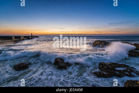 Sonnenuntergang über dem Atlantik. Ansicht mit kleiner Leuchtturm (Farolins Barra Douro) in Foz Douro Bezirk von Porto Stadt, Portugal Stockfoto