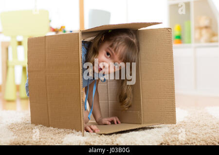 Kind Mädchen spielen in einer Pappschachtel Stockfoto