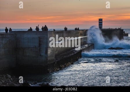 Sonnenuntergang über Wellenbrecher mit kleinen Leuchtturm genannt Farolins da Barra do Douro in Foz Do Douro Bezirk von Porto Stadt, Portugal Stockfoto