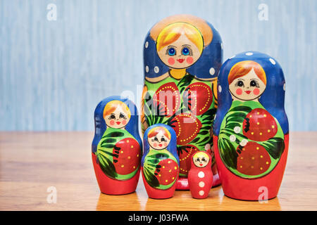 Satz von russischen Puppen stehen neben einem Holztisch Stockfoto