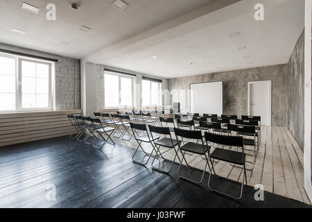 Leeren moderne Klassenzimmer mit schwarzen Stühlen Leinwand Stockfoto