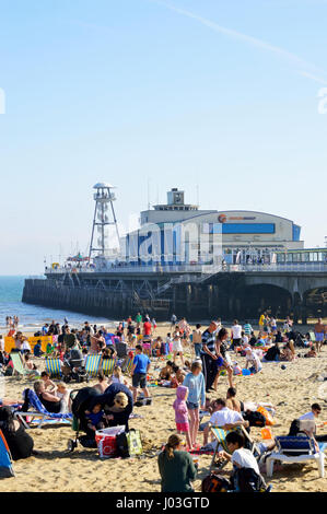 Menschen Sonnenbaden an überfüllten Strand von Bournemouth mit Bournemouth Pier im Hintergrund in 2017, Dorset, Großbritannien Stockfoto