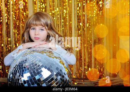 Kleines Mädchen mit Discokugel Ang gold sparcles Stockfoto