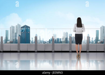 Porträt von asiatischen Geschäftsfrau stehen auf einer Terrasse und mit Blick auf moderne Stadt Stockfoto