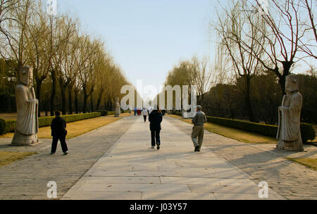 Besucher zu Fuß entlang der Heiligen Straße in der Nähe der Ming-Gräber. Peking, China. Am späten Nachmittag an einer frühen Frühlingstag mit den Bäumen, die gerade erst auf grün. Stockfoto