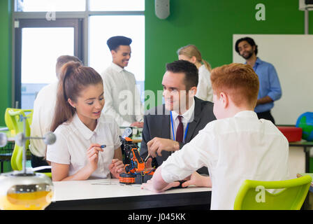Schüler bauen einen Roboterarm. Der Lehrer ist ihre Technik mit ihnen diskutieren. Stockfoto