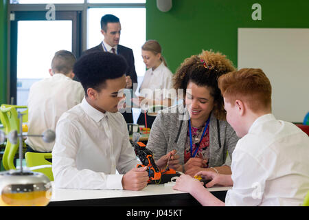 Schüler bauen einen Roboterarm. Der Lehrer ist ihre Technik mit ihnen diskutieren. Stockfoto