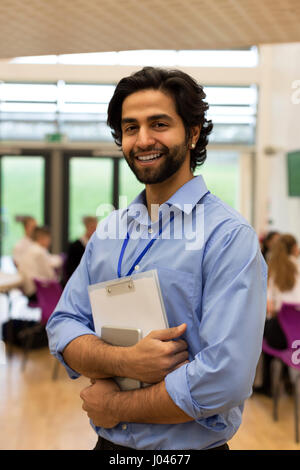 Taille Porträt einer Lehrerin. Er hält einige Papiere und eine digital-Tablette. Stockfoto