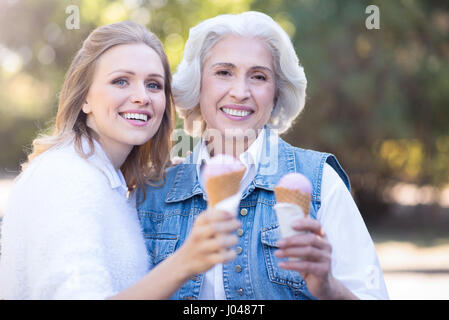 Glückliche junge Frau Eis mit alten Mutter Natur zu genießen Stockfoto