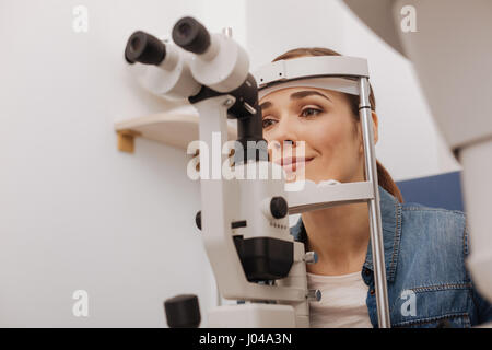 Positive, attraktive Frau mit Auge Prüfgeräte Stockfoto