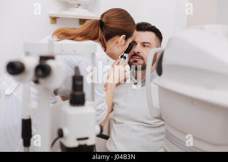 Professionelle erfahrenen Augenarzt mit einem Ophthalmoskop Stockfoto