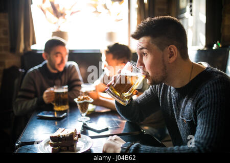 Mann Bier trinken an zu trinken Freunde im Pub zu diskutieren. Stockfoto