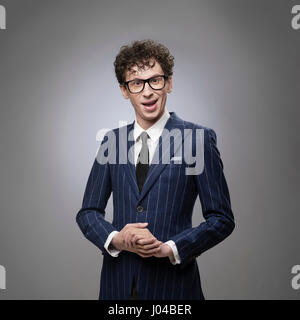 Lustig schockiert Mann im gestreiften Anzug. Professionelle Schauspieler Gesichtsausdruck. Wirklich? Was? Fragen, schockiert, lächelnd, verblüfft, überrascht Emotion. Stockfoto