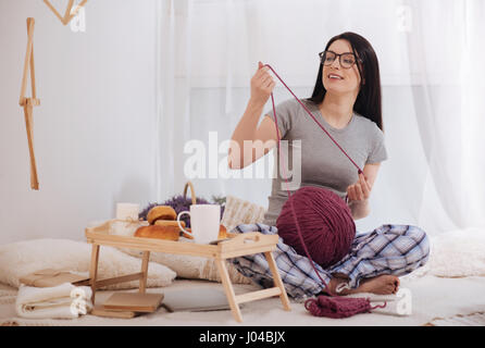 Charmante Frau mit Wollknäuel zu Hause Stockfoto