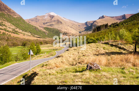 Eine kleine Landstraße schlängelt sich durch Wiesen und Wälder in der Talsohle des Glen Nevis unter den Bergen des Ben Nevis in den West Highlands S Stockfoto