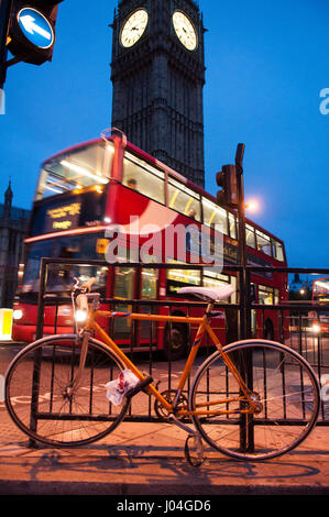 London, England - 15. Juni 2011: Ein Fahrrad ist im Parliament Square außerhalb des Parlamentsgebäudes angekettet wie ein Morgen Bus die legendäre Big fährt Stockfoto