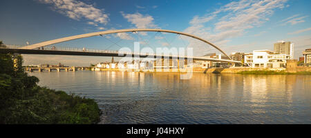 Abendlicht beleuchtet das Stadtbild von Maastricht in den Niederlanden, einschließlich der Maas und der hochrangigen Fußgängerbrücke, De Hoge Brug. Stockfoto