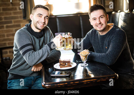 Zwei schöne Freunde in einem Pub mit Glas Bier. Stockfoto