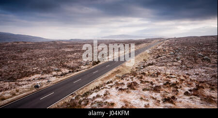 Die A82 Straße folgt einen geraden Weg durch die weiten, leeren und gefrorene Landschaft des Rannoch Moor in den westlichen Highlands von Schottland. Stockfoto