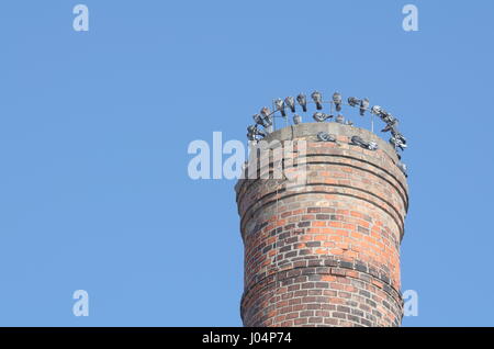 Grauen Tauben sitzen auf Fabrikschornsteinen oben an einem sonnigen Tag Stockfoto