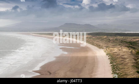 MOEL-y-Gest und andere Berge des Snowdonia National Park steigen hinter dem langen Strand und Sand Dune-System bei Morfa Harlech in Nord-Wales. Stockfoto