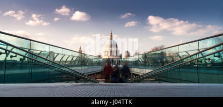 Fußgänger überqueren die Themse auf der Millennium Bridge zwischen Bankside und der City of London, die Kuppel der St. Pauls Kathedrale hinter. Stockfoto