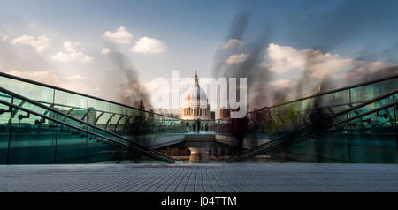 Fußgänger überqueren die Themse auf der Millennium Bridge zwischen Bankside und der City of London, die Kuppel der St. Pauls Kathedrale hinter. Stockfoto