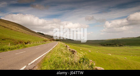 Die alten Manchester-Sheffield-Straße führt durch Felder der Schafweiden auf den sanften Hügeln des White Peak District in der Nähe von Castleton in Derbyshire. Stockfoto