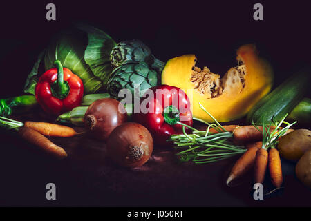 Gesunde Ernährung-Konzept mit frischem Gemüse auf dunklem Hintergrund. Rustikalen Stil. Stockfoto