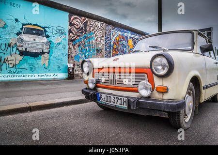 Berühmte Berliner Mauer (Berliner Mauer) in der East Side Gallery mit einer alten Trabant, das häufigste Fahrzeug verwendet in der DDR, Berlin, Deutschland Stockfoto