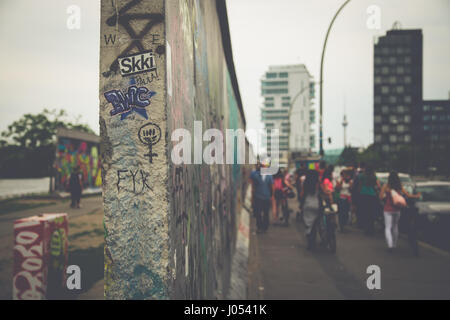 Panoramablick auf der berühmten Berliner Mauer dekoriert mit bunten Graffiti Streetart in historischen East Side Gallery auf einem stimmungsvollen bewölkten Tag mit Retro-Vintage Stockfoto