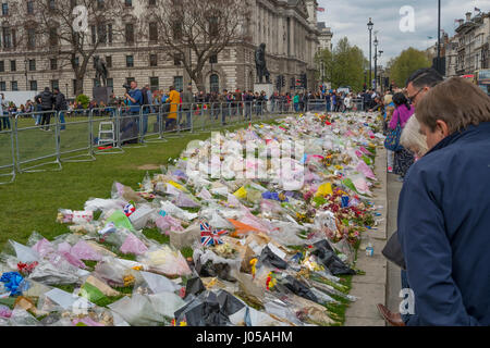 Parliament Square, London, UK. 10. April 2017. Voller Kraft Beerdigung von PC Keith Palmer, getötet in der Westminster-Terroranschlag vom 22. März, findet in der Southwark Cathedral am Montag 10. April um 14:00. Fußgänger passieren die Blütenpracht in Parliament Square im Gedenken derer, die bei dem Angriff getötet. Bildnachweis: Malcolm Park Leitartikel/Alamy Live-Nachrichten. Stockfoto