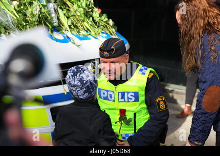 Emotionale Szenen auf dem Gelände des Stockholm-Lkw-Angriff. Menschen sind gekommen, um Blumen am Sonntag nach dem Angriff auf ein Polizeiauto zu legen. Stockfoto