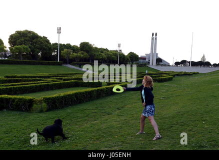 Lissabon, Portugal. 9. April 2017. Eine Frau spielt mit ihrem Hund im Park Eduardo VII in Lissabon, Hauptstadt von Portugal, am 9. April 2017. Bildnachweis: Zhang Liyun/Xinhua/Alamy Live-Nachrichten Stockfoto