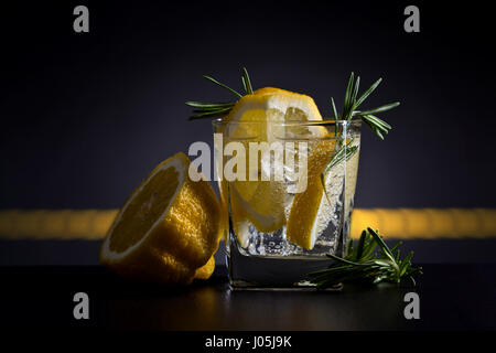 Cocktail mit Gin, Tonic, Zitrone und Eis. Cocktail mit Rosmarin und Zitrone Zitronenscheibe garniert. Stockfoto