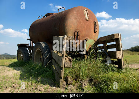 Alten mobile Zisterne mit Wasser auf dem Land. Verlassene alte rostige Auto Anhänger Tank im Feld. Stockfoto