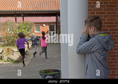 Schülerinnen und Schüler an der Grundschule spielen verstecken und suchen in Pause, Niedersachsen, Deutschland Stockfoto