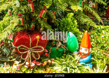 Gartenzwerg, umgeben von Pflanzen und Bäumen Stockfoto