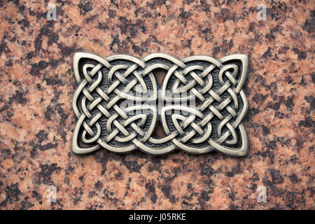 Gusseisen keltischen Knoten auf einer Steinoberfläche. Stockfoto