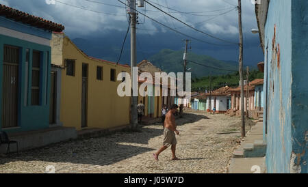 Mann überqueren einer Straße mit Kopfsteinpflaster in Trinidad, Kuba Stockfoto