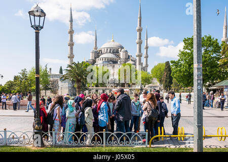 Die Sultan Ahmed Mosque oder Sultan-Ahmet-Moschee ist eine historische Moschee befindet sich in Istanbul, Türkei. Ein beliebtes Touristenziel, die Sultan Ahmed Mosque weiterhin als Moschee heute funktionieren; Männer knien noch im Gebet auf die Moschee üppigen roten Teppich nach dem Aufruf zum Gebet. Die blaue Moschee, wie es im Volksmund bekannt ist, wurde zwischen 1609 und 1616 während der Herrschaft von Ahmed gebaut ich. Die Külliye enthält Ahmeds Grab, eine Madrasah und ein Hospiz. Wunderschöne handbemalte blaue Fliesen schmücken die Moschee Innenwände, und nachts ist die Moschee in Blau getaucht, wie Lichter fünf wichtigsten Kuppeln der Moschee Rahmen, s Stockfoto