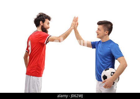 Vater und Sohn gekleidet in Sport Trikots hohe Fiving einander isoliert auf weißem Hintergrund Stockfoto