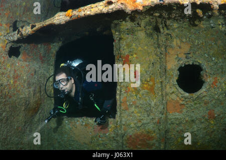 Ein Taucher untersucht das Wrack. UNHEIMLICHE Unterwasser Bilder zeigen im Inneren das Wrack des gesunkenen britischen Weltkrieg zwei Schiff SS Thistlegorm am fünfundsiebzigsten Jahrestag von ihrem Untergang. Die Bilder zeigen die verrosteten Überreste der Handelsmarine der Schiffsfracht umfasst Motorräder, Armee-LKWas und ein Flugzeug-Propeller. Andere Bilder zeigen, wie Leben im Meer haben bewohnen das Wrack. Stockfoto